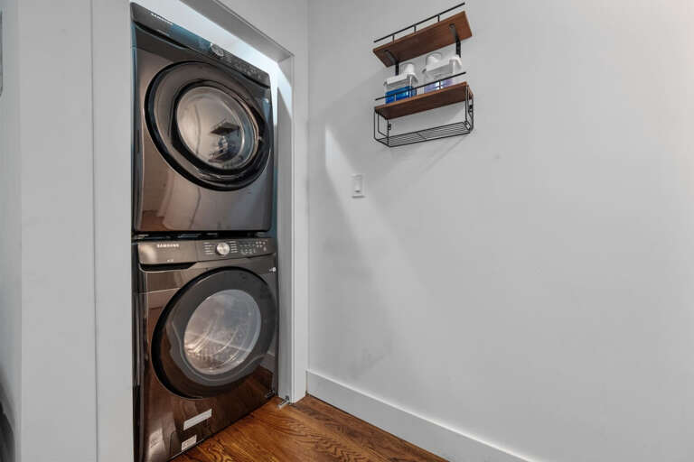 Full Size Washer and Dryer, stacked on top of each out, in hallway area between rooms and living areas