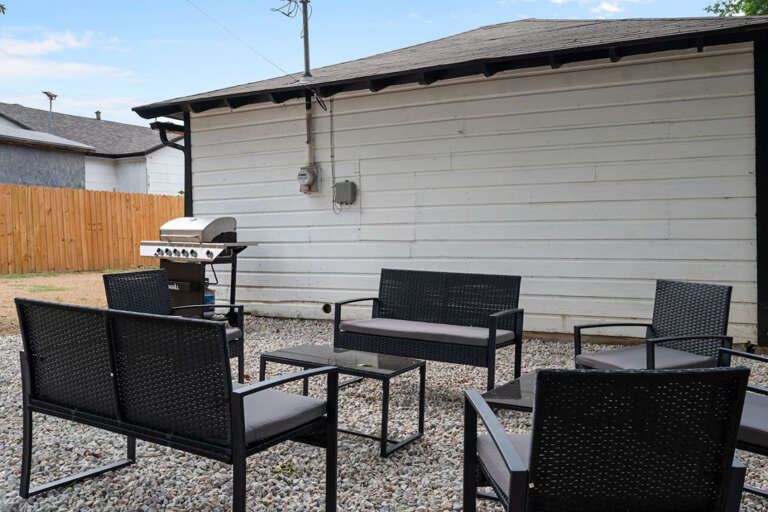 Backyard Outdoor Stone Gravel Sitting and Grill Area.