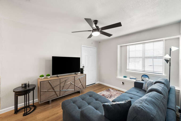 Living room with convertible full sized couch, Samsung TV, view entry door