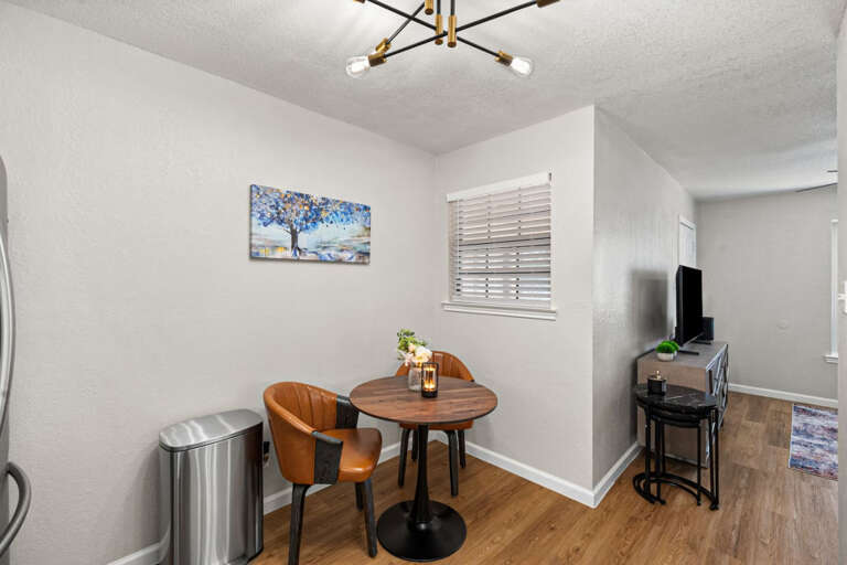 Dining area in kitchen showing 2 seating at dining, and into living area