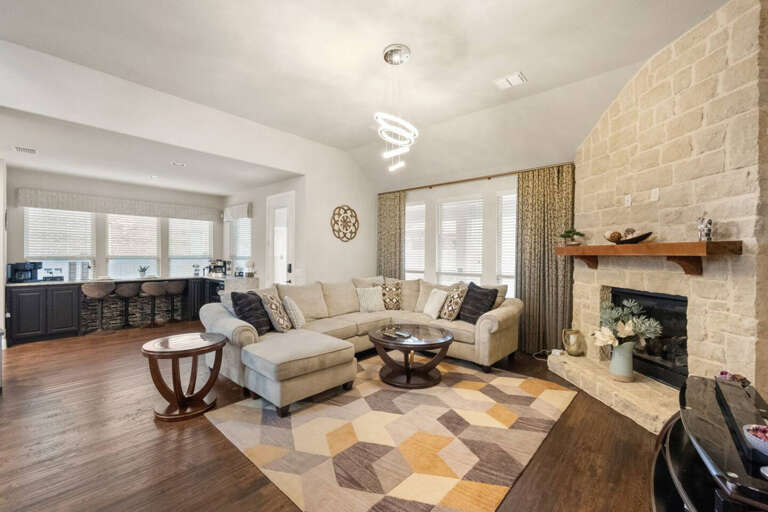 View of living room seating area, looking into breakfast nook, bar area, and back exit door to backyard.