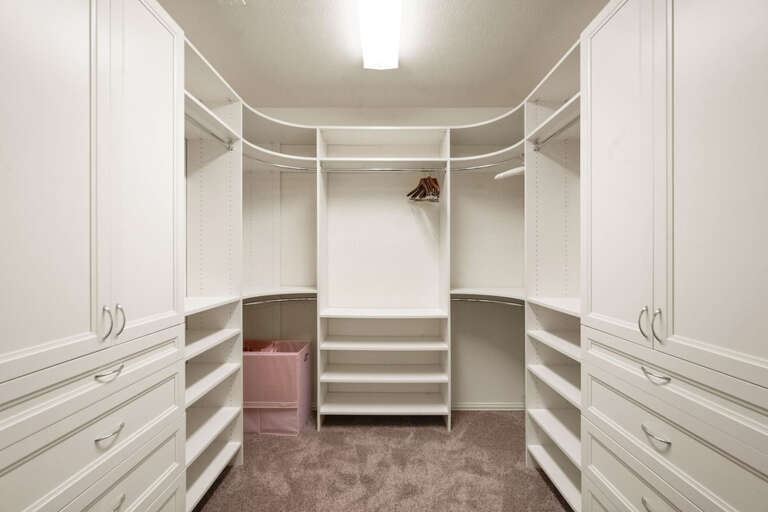 Downstairs primary bedroom's large open walk in closet with hangers and plenty of room for your clothing