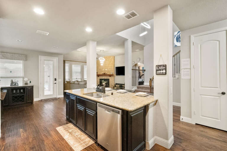 Downstairs full kitchen, showing island sink and bar sitting area, looking back into main living area.
