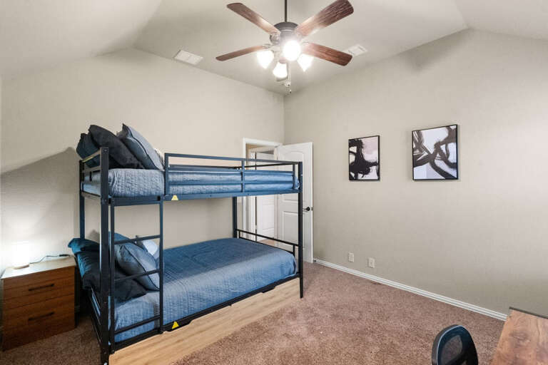 2nd Floor middle bunk bed room, with 2 full beds on the bunk bed, 2 closets, TV for streaming, and desk area. Showing nightstand next to beds, and exit door to hallway.
