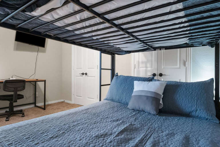 2nd Floor middle bunk bed room, with 2 full beds on the bunk bed, 2 closets, TV for streaming, and desk area.