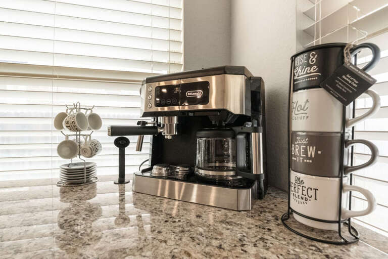 Detail view of espresso machine, and prep areas with coffee and espresso cups