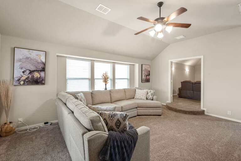 Upstairs living room area, showing sectional couch recliner closed, looking back into media room.