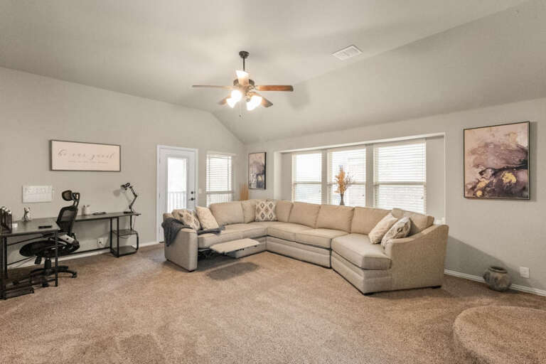 Upstairs living room area, showing sectional couch recliner opened, desk area, looking toward 2nd floor balcony door.