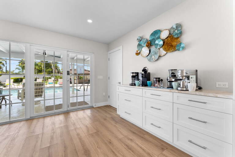 Your counter has a Keurig, drip, and French press — every coffee preference covered before the morning beach run, and French doors opening right to the pool.