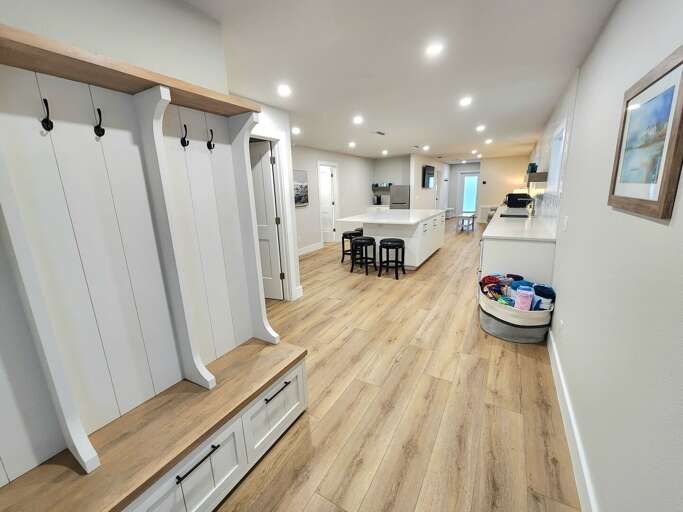 Drop your beach gear at the mudroom hooks and bench, then you're right at the kitchen island — clean flow from outside to inside.