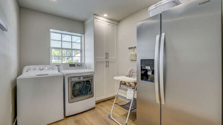 Full-size washer, dryer, extra fridge, and a high chair for your little ones — the laundry room is stocked for a real stay, not just a weekend.
