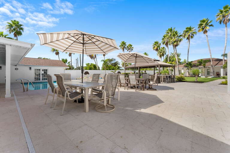 Your pool patio has outdoor dining tables under umbrellas for the group breakfast, the lunch spread, and the late-afternoon stories that go until dinner.
