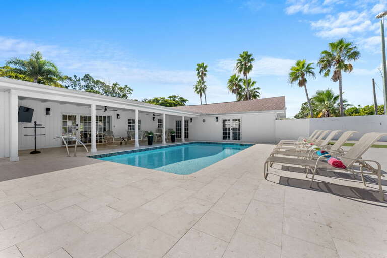 Your view from the covered porch — pool right in front of you, house behind you, and nowhere to be.