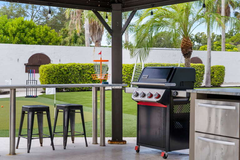 Your Weber gas grill sits under the gazebo and is ready to go — you're cooking in ten minutes flat with a cold drink already in hand.