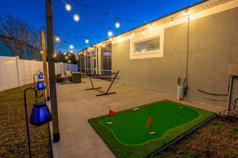 Your backyard comes loaded with reasons to stay outside — putting green, hammock, and string lights included