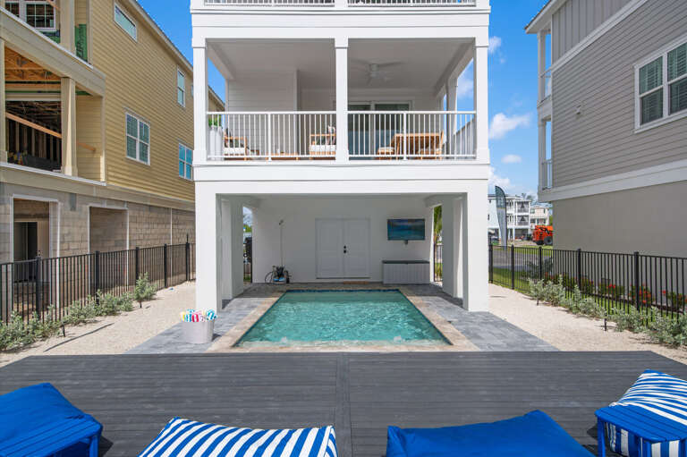 Covered pool area from the rear — the pool is sheltered on two sides so you can use it even when the afternoon sun is full strength.