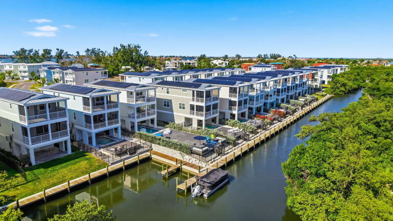 Every home in the row has its own dock slips along the canal — the kind of community that was built specifically for people who bring their boats.