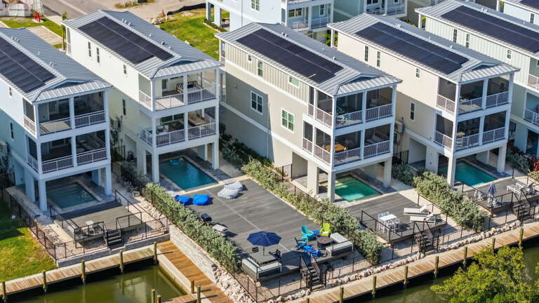 From above you can see what sets this community apart — every home has solar panels, and a private dock right on the canal.
