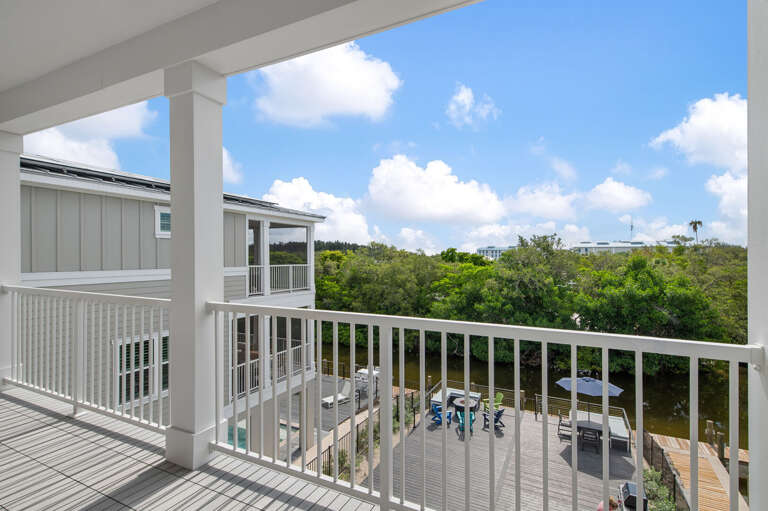Stand at the upper balcony and you've got eyes on the deck, the canal, and the tree canopy all at once — your own elevated perch above the whole backyard.