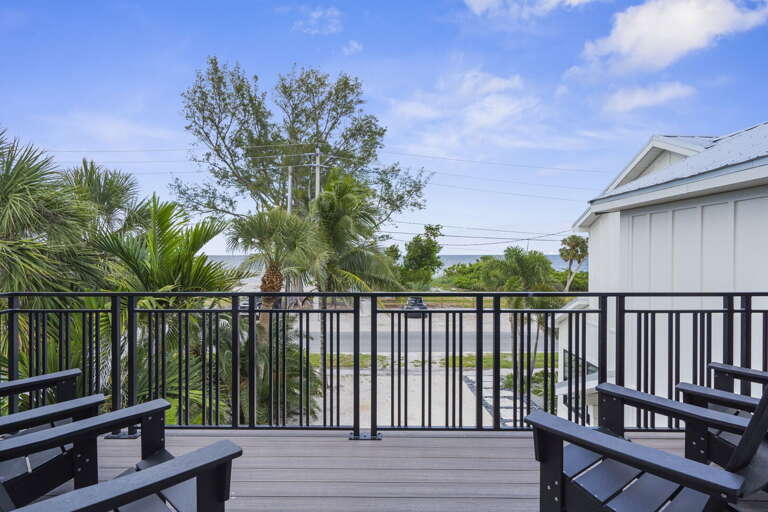 See the whole picture from here — lush landscaping, clean facade, and a beachfront position that's hard to believe until you're standing in it.