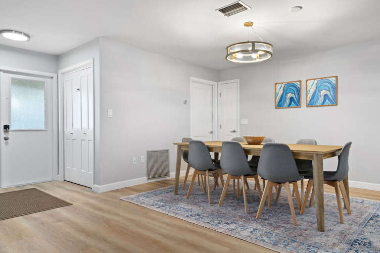 Gather the whole group for a real sit-down meal — the pendant chandelier sets the mood and the table fits everyone comfortably.