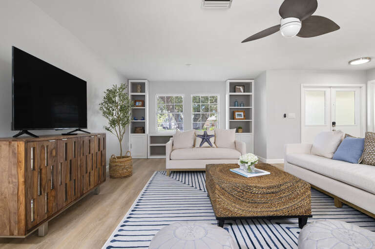 Pick a sofa and start the movie — two white sectionals face the screen and nobody ends up on a bad seat.