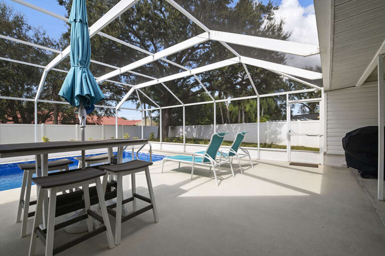 Set up here with a cold drink after a swim — the bar-height table is the poolside happy hour spot you will love.