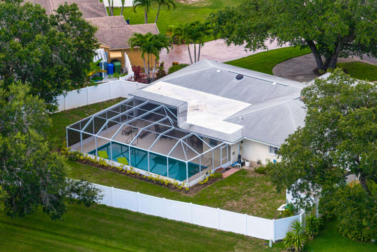 Your own slice of Florida — a private screened pool, lush yard, and two-car garage, all wrapped in mature oak trees.