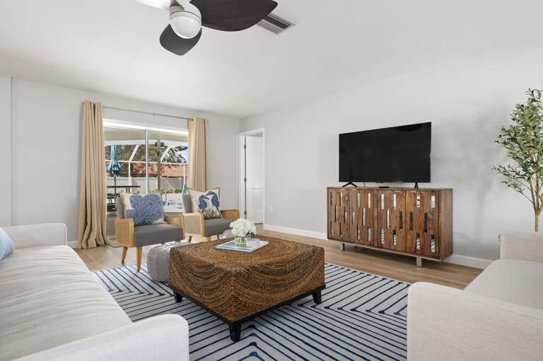 Stream your show or slide those doors open to the pool — this living room handles both vacation moods without missing a beat.