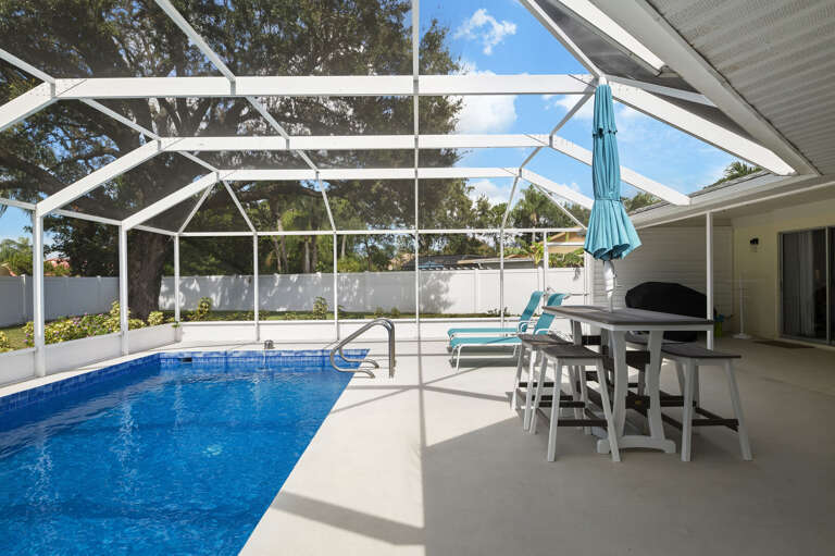 Wade in from the shallow end — the pool steps make it easy for every age to get in, and the bar stool is right there waiting.