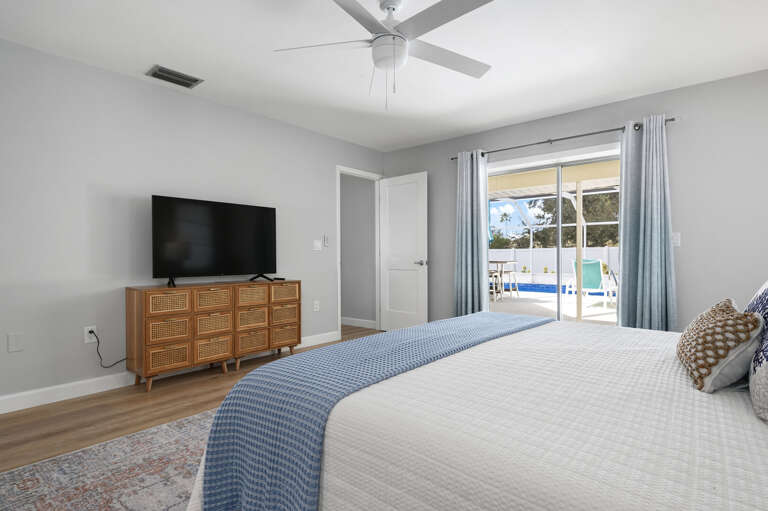 Wake up to a king bed and a screened pool right outside the slider — the primary suite makes the early morning the best part of the trip.