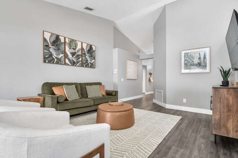 Your eye will keep coming back to those orange accent pillows — the whole palette was pulled together on purpose and it shows.