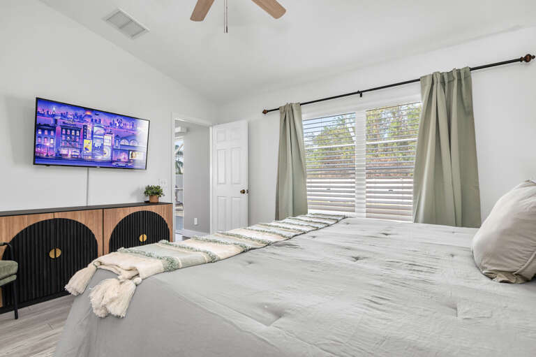 Sleep in without guilt — the sage green curtains filter Florida light to a gentle glow, keeping the room cool even when it's bright outside.