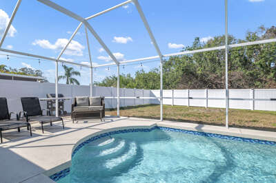 Step outside and your private heated pool is waiting — cool blue water, loungers, and total privacy in the screened enclosure.