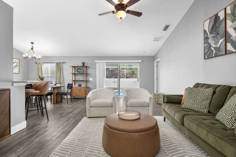 Watch the kids splash from the couch without leaving the air conditioning — the living room flows straight to the pool deck.