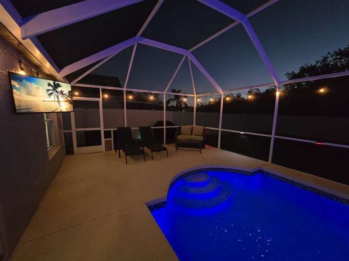 Watch the pool transform after dark — string lights overhead, the TV on, and your whole evening just got better.