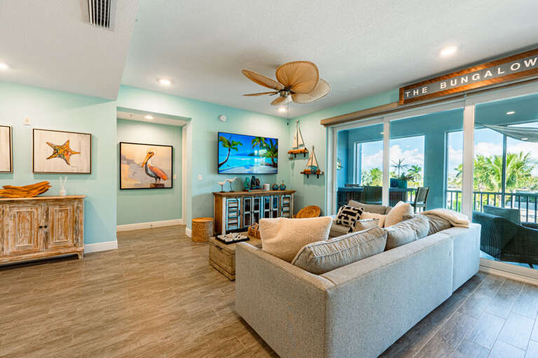 Gather here after dinner — the Smart TV and Sonos are ready, and the coastal art gives the whole room a beach-house feel.