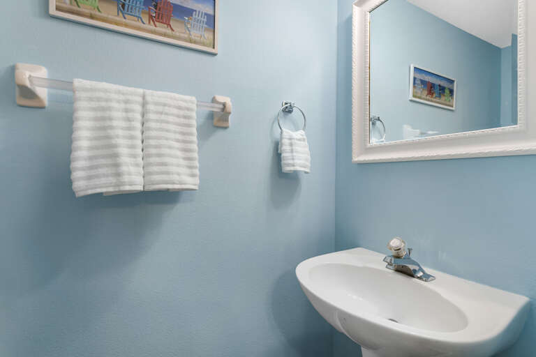 Grab a fresh striped towel and step into your blue coastal bathroom — it's stocked and waiting for you.