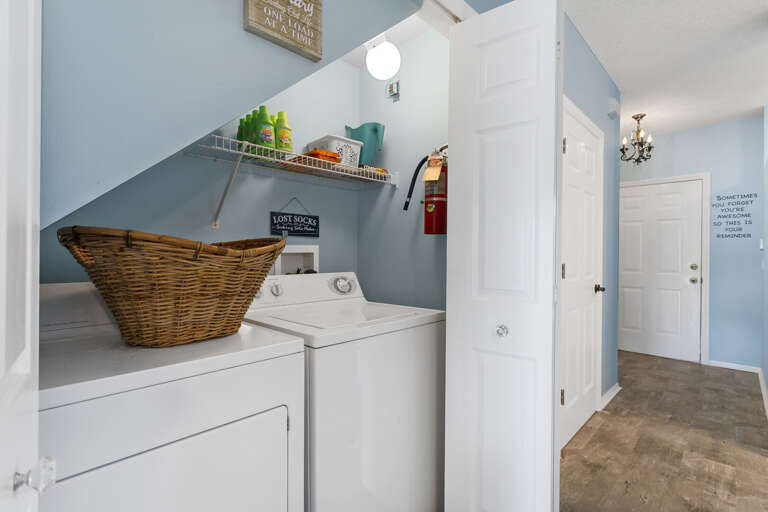 Pack light and do laundry on-site — full-size washer and dryer tucked neatly under the stairs.