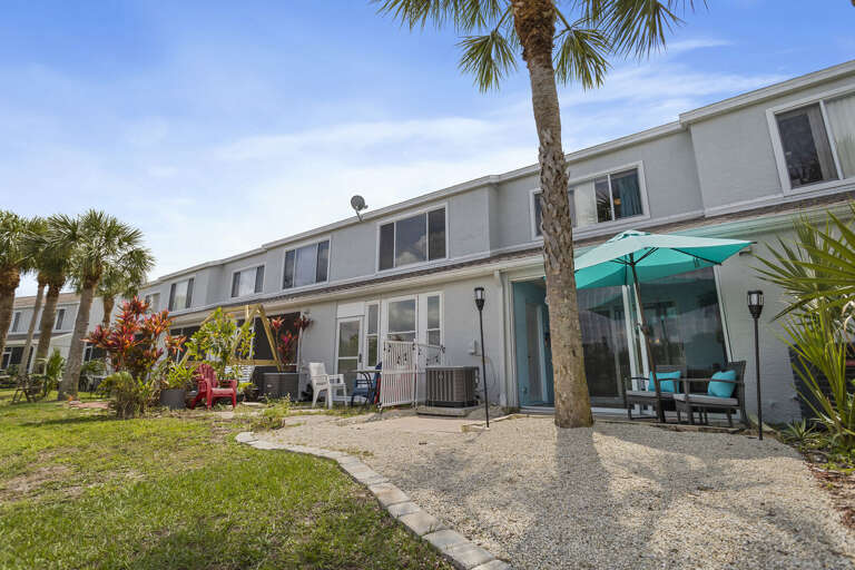Your two-story townhouse sits steps from tropical greenery and your own private rear patio seating.