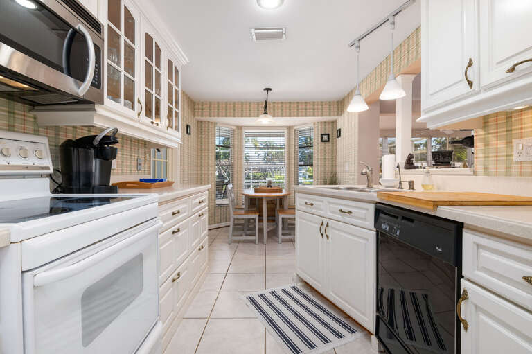 Cook with every tool you need — from the stove to the microwave, with pendant-lit breakfast window keeping the kitchen feeling open.