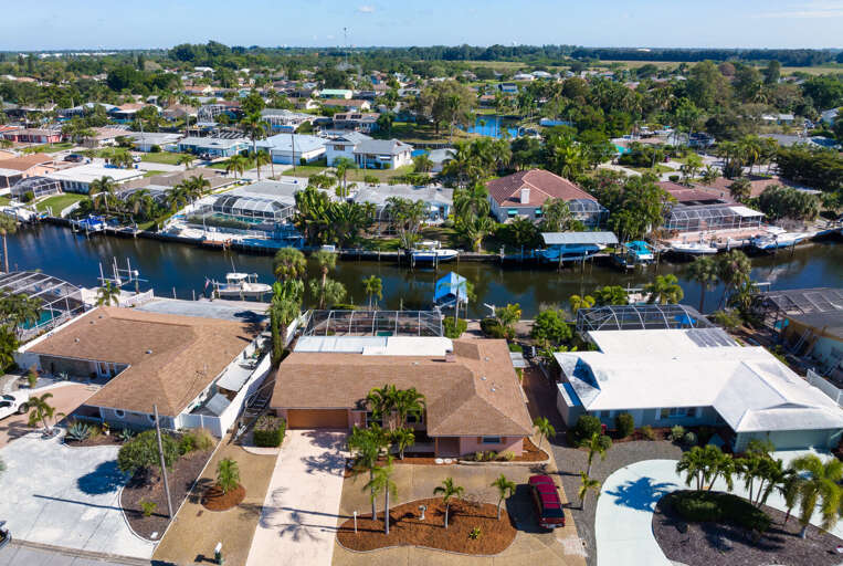 Discover exactly why this address books out fast — an aerial view reveals the screened pool, private dock, and direct canal access all in one shot.