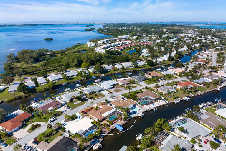 Find your specific property from above — screened pool, dock with boat lift, and direct canal access all visible in one tight frame.
