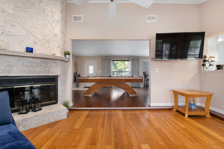 Pull up after dinner, flip on the mounted TV, or slide open the pass-through to the billiards room — this living space keeps everyone in the same loop.