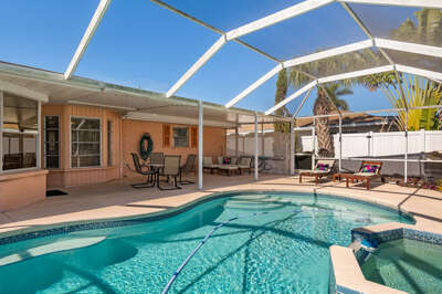 Sink into vacation the moment you step out back — your screened heated pool is waiting, with patio loungers ready for a sun-soaked afternoon.