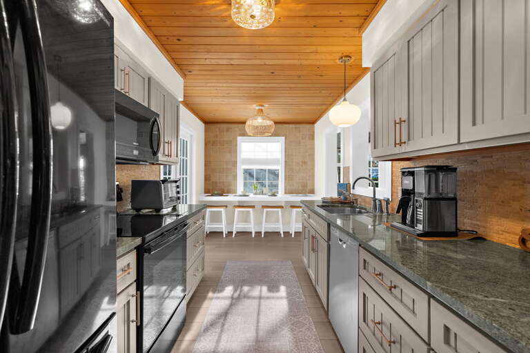 Cook a full breakfast for eight without running out of counter space — the galley layout is efficient, the pendant lights are warm, and the granite counters wipe clean in thirty seconds.