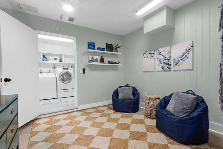 Drop into a bean bag and claim your corner of the game room — checkered floors, open space, and easy access to the laundry so the pool towels cycle while everyone plays.