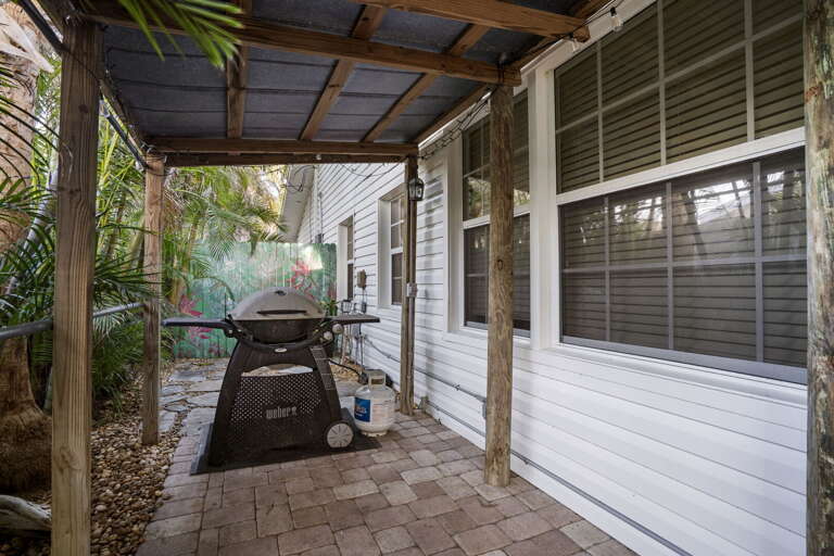 Fire up the Weber and keep the grill master out of the sun — the covered pergola turns outdoor cooking into a genuine pleasure even on hot Florida afternoons.