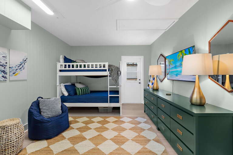 Pack the kids into the bunk room and watch the adults reclaim the rest of the house — TV, bean bags, and blue bedding make this the most fought-over room for guests under fourteen.