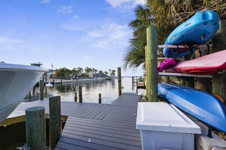 Pull a kayak off the rack and head out before the rest of the house wakes up — the canal is glassy at dawn and the neighborhood is completely still. Best morning call you will make all week.